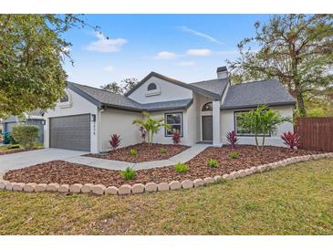 Charming one-story home with a beautifully landscaped front yard, fresh mulch, and healthy plants at 3038 Longbrooke Way, Clearwater, FL 33760