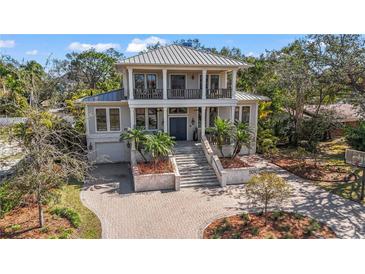 Stately two-story home with a metal roof, brick driveway, and well-manicured landscaping at 5010 W Dickens Ave, Tampa, FL 33629