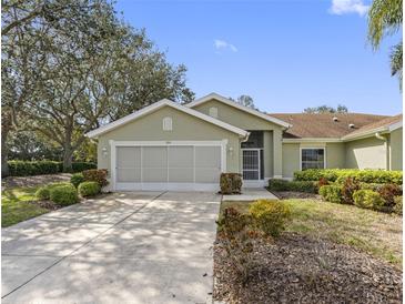 Charming one-story home featuring a two-car garage, well-maintained landscaping, and a cozy entrance at 988 Villeroy Greens Dr, Sun City Center, FL 33573