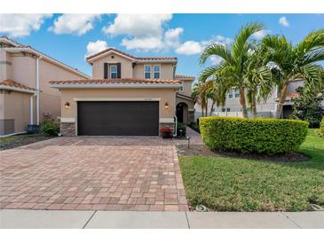 Charming two-story home with a well-manicured lawn, beautiful red brick driveway and tile roof at 10136 Grand Oak Cir, Madeira Beach, FL 33708
