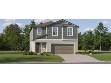 Charming two-story home with blue siding, a well-manicured lawn, and an attached two-car garage at 9452 Runaway Breeze Dr, Land O Lakes, FL 34637