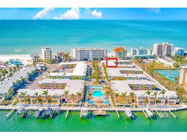 Breathtaking aerial view of beachfront property showcasing docks, pool and stunning ocean views at 19417 Gulf Blvd # D-206, Indian Shores, FL 33785