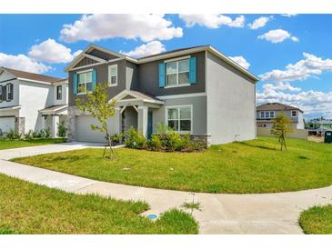 Beautiful two-story home features blue shutters, stone accents, and a well-maintained lawn in a Gathering-friendly neighborhood at 31818 Treasure Dock Isle, Wesley Chapel, FL 33545