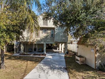 Inviting stilt home featuring a large driveway, shed, and a covered area for parking and outdoor seating at 6291 Sebring St, Weeki Wachee, FL 34607