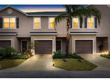 Inviting exterior view of townhomes, showcasing dark shutters and a lush, landscaped lawn at sunset at 1034 Grantham Dr, Sarasota, FL 34234
