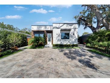 Charming home featuring modern brickwork, wood accents, neat landscaping, and a stylish brick driveway at 3106 Lila St, Tampa, FL 33610