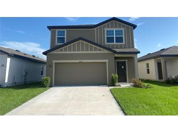 Charming two-story home with a well-manicured lawn and a spacious two-car garage at 35220 White Water Lily Way, Zephyrhills, FL 33541