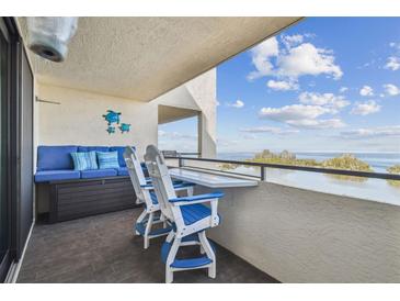 Cozy condo balcony with comfortable blue seating and a stunning view of the bay at 5915 Sea Ranch Dr # 703, Hudson, FL 34667