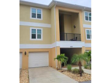 Charming two-story condo with a one-car garage, quaint landscaping, and covered balcony at 6421 Banyan Blvd # 302, New Port Richey, FL 34652