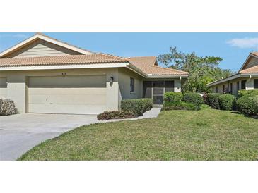 Charming one-story home with a well-maintained lawn, beige exterior, and an attached two-car garage at 7245 Wood Creek Dr # 29, Sarasota, FL 34231