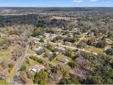 An aerial view showcases a residential neighborhood surrounded by lush greenery and trees at 10171 Patrick St, Brooksville, FL 34601