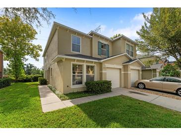 Charming two-story townhome featuring a well-manicured lawn and attached garage at 2032 Sunset Meadow Dr, Clearwater, FL 33763