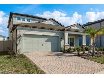 Charming two-story home with a brick driveway and attached two car garage at 3042 Marine Grass Dr, Wimauma, FL 33598