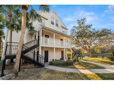 Beautiful exterior view of a multi-story building with balconies, black steel stairs, and mature trees in a well-maintained community at 3300 Haviland Ct # 304, Palm Harbor, FL 34684