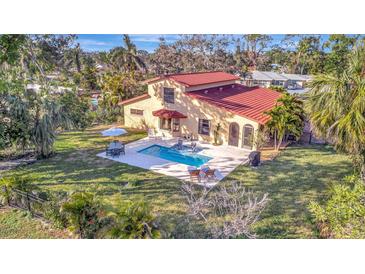 Aerial view of a home with a pool, patio, lush landscaping, and outdoor seating at 612 Montezuma Dr, Bradenton, FL 34209