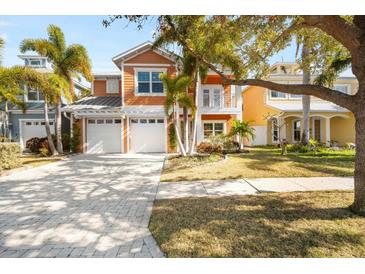 Beautiful two-story home featuring a two-car garage, well-manicured lawn, and tropical palm trees at 6411 Grenada Island Ave, Apollo Beach, FL 33572