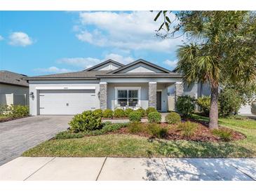 Charming single-story home featuring a well-maintained lawn and a cozy front porch area with stone accents at 10132 Tuscan Sun Ave, Riverview, FL 33578