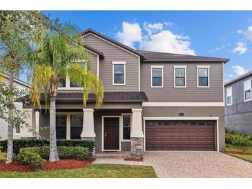 Inviting two-story home features a manicured lawn, lush landscaping, and a two-car garage at 19429 Paddock View Dr, Tampa, FL 33647