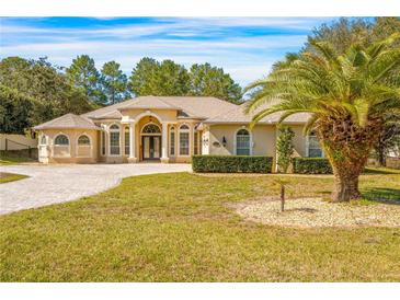 Stunning one-story home with a circular driveway and lush landscaping at 10159 Hernando Ridge Rd, Weeki Wachee, FL 34613