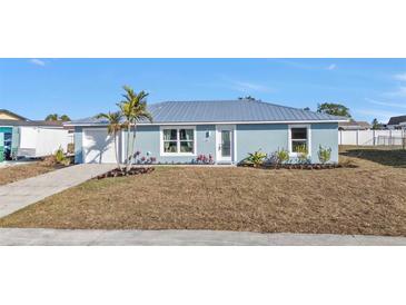 Charming single-story home featuring a metal roof and a well-manicured front yard at 13526 Alberta Ave, Port Charlotte, FL 33981