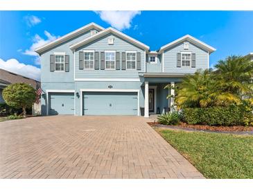 Charming two-story home with a well-maintained lawn and a brick driveway leading to a two-car garage at 18329 Roseate Dr, Lutz, FL 33558