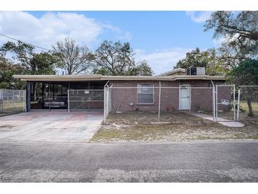 Charming brick home featuring a fenced yard and a covered parking area at 3817 N 54Th St, Tampa, FL 33619