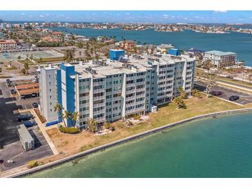 Wide aerial view of a beachfront apartment complex overlooking the water with well-maintained landscaping at 500 Treasure Island Cswy # 404, Treasure Island, FL 33706