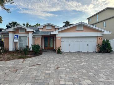 Charming single Gathering home with a three car garage and large, light brick driveway at 567 Baywood S Dr, Dunedin, FL 34698