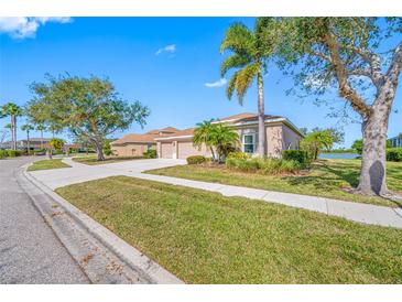 Charming single-story home with a well-maintained lawn, mature trees, and a three car garage at 833 Seminole Sky Dr, Ruskin, FL 33570