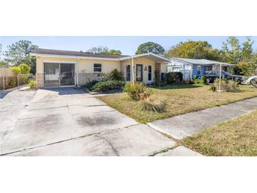 Charming single-story home with a yellow exterior, stone accents, and a spacious driveway at 4408 W Lackland Pl, Tampa, FL 33616