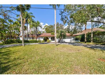 Charming single story home with an arched entrance and a well maintained front yard surrounded by mature trees at 4609 W San Miguel St, Tampa, FL 33629