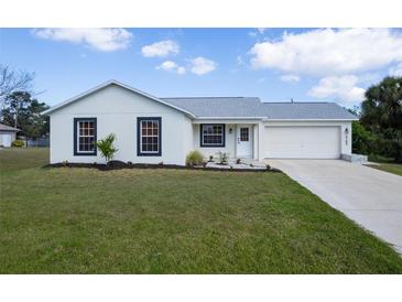 Charming home featuring a well-maintained lawn and a bright, freshly painted exterior at 6160 Van Dine St, Englewood, FL 34224