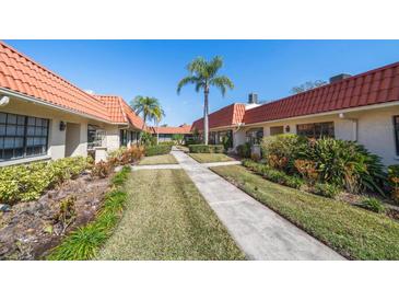 Attractive community featuring sidewalks, mature landscaping, and terra cotta roofs at 19029 Us Highway 19 N # 19C, Clearwater, FL 33764