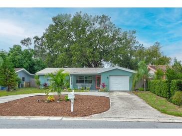 Charming single-story home featuring lush landscaping, a well-manicured yard, and a welcoming entrance at 2405 Indigo Dr, Clearwater, FL 33763