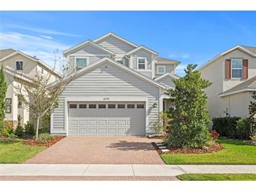 Charming two-story home featuring a brick driveway, a two-car garage, and well-maintained landscaping at 6219 Voyagers Pl, Apollo Beach, FL 33572
