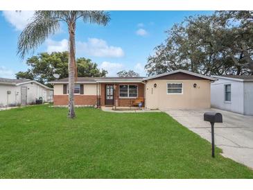 Charming single Gathering home with well maintained lawn, mature landscaping, and inviting curb appeal at 9040 Lunar Ln, Port Richey, FL 34668