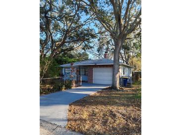 Charming single-story home with a brick facade and mature trees in a well-maintained yard at 1003 Engman St, Clearwater, FL 33755