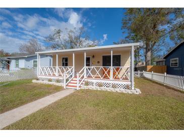 Lovely bungalow featuring a welcoming front porch, decorative trim, and verdant lawn at 1053 56Th N Ave, St Petersburg, FL 33703