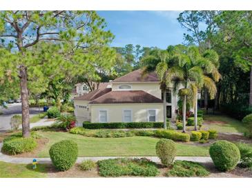 Charming home featuring a well-manicured lawn, mature trees, and lush landscaping at 15901 Benton Ct, Tampa, FL 33647