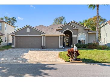 Charming single-story home with a three-car garage and a beautifully landscaped front yard at 2037 Blue River Rd, Holiday, FL 34691