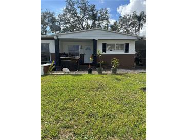 Modest single-story home with a simple front yard and mature trees providing shade at 2102 W Ivy St, Tampa, FL 33607