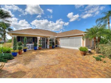 Charming single-story home boasting a brick driveway and meticulously landscaped front yard at 2359 Emerald Lake Dr, Sun City Center, FL 33573