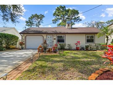 Charming single-story home with a well-manicured lawn, brick-lined walkway, and attached garage at 2940 Bay View Dr, Safety Harbor, FL 34695