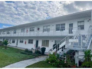 Two-story condo building featuring stairs, balconies, and well-maintained landscaping at 5895 18Th N St # 11, St Petersburg, FL 33714