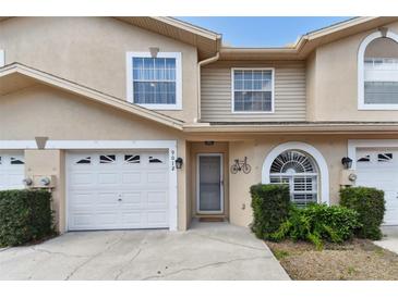 Charming townhome with a well maintained front yard, featuring a garage and decorative front entrance at 9012 Antigua Dr, Seminole, FL 33777