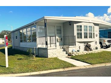 Charming single-story home with well-maintained lawn and welcoming front porch with lovely brick facade at 9790 66Th N St # 235, Pinellas Park, FL 33782