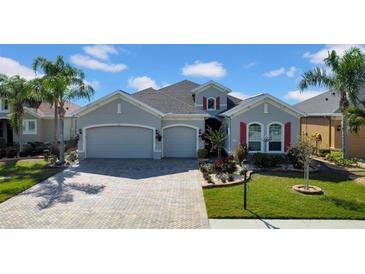 Charming single-Gathering home with a three-car garage, manicured lawn, and beautiful landscaping at 1545 Emerald Dunes Dr, Sun City Center, FL 33573