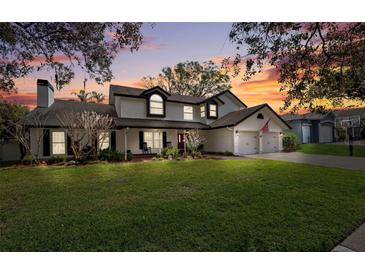 Charming two-story home with an expansive green lawn and a welcoming two-car garage, perfect for suburban living at 759 Timuquana Ln, Palm Harbor, FL 34683