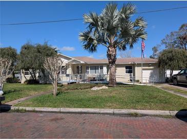 Charming single-story home with a well-manicured lawn, a lovely palm tree, and a convenient access ramp at 903 W Plymouth St, Tampa, FL 33603