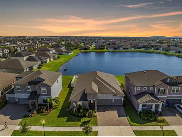 Sunset aerial view of waterfront home featuring lush landscaping and picturesque water views at 11717 Navajo Sandstone St, Riverview, FL 33579